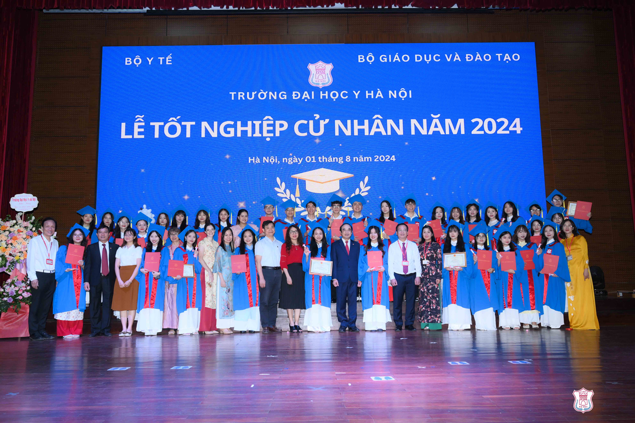 A group of people standing in front of a large blue sign

Description automatically generated